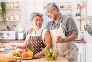 senior couple enjoying preparing a salad together in the kitchen